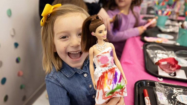 Evie Ladd with the doll dress she colored and decorated...