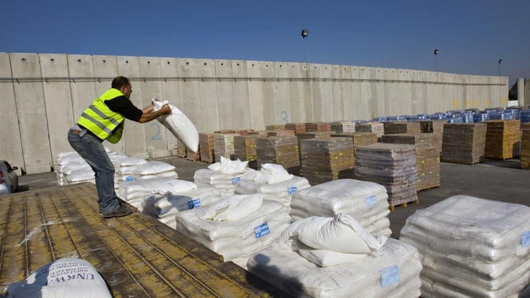 An Israeli worker moves a bag of UN humanitarian aid...
