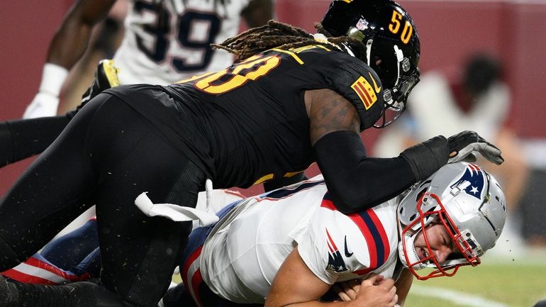 New England Patriots quarterback Drake Maye, bottom, is tackled after...