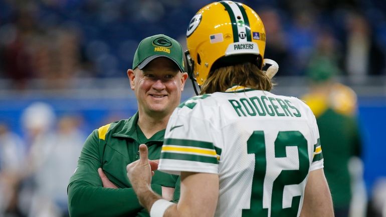  Packers offensive coordinator Nathaniel Hackett talks with quarterback Aaron Rodgers...