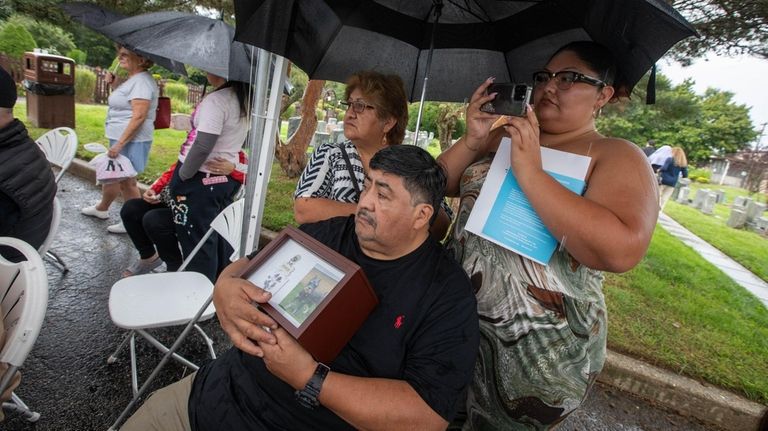 Abraham Sanchez, of Queens, holds a photo of his dog,...