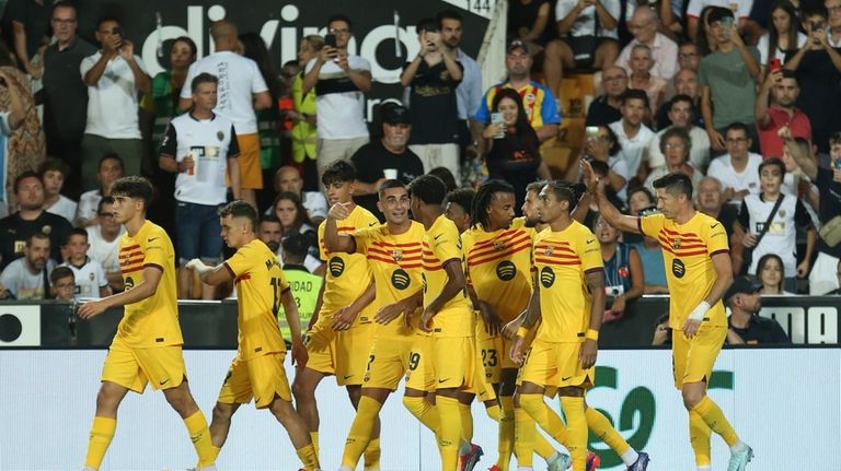 Barcelona's Robert Lewandowski, right, celebrates with teammates after scoring his...