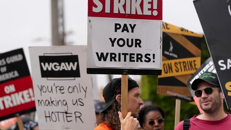 Demonstrators hold signs during a rally outside the Paramount Pictures...