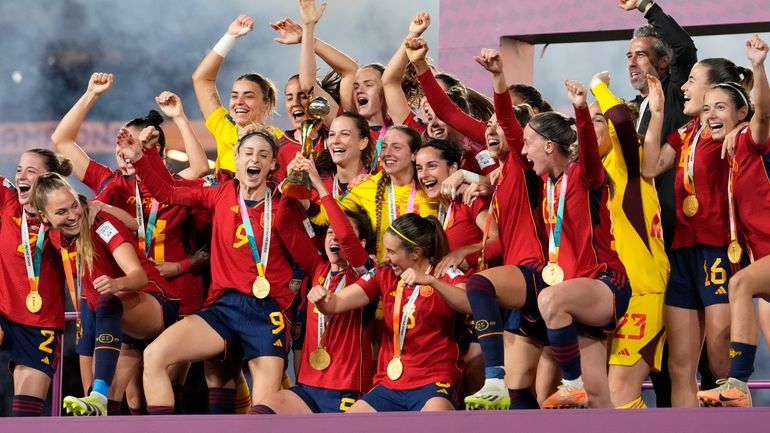 Spain players celebrate with the trophy at the end of...