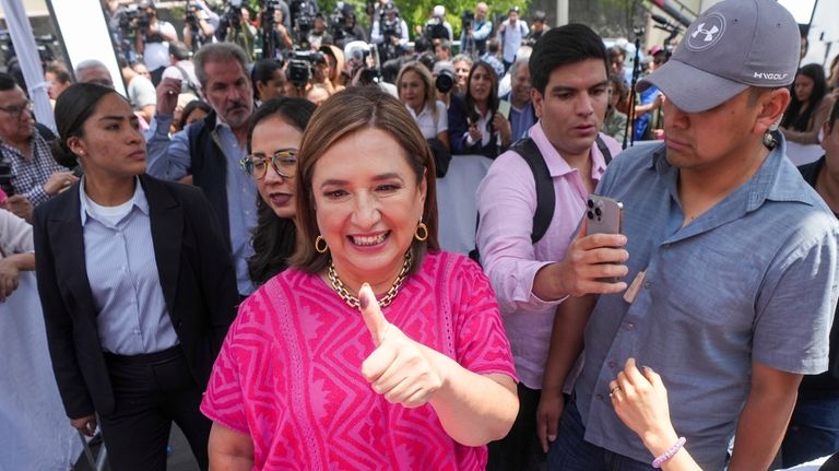 Opposition presidential candidate Xóchitl Gálvez shows her inked-stained thumb as...