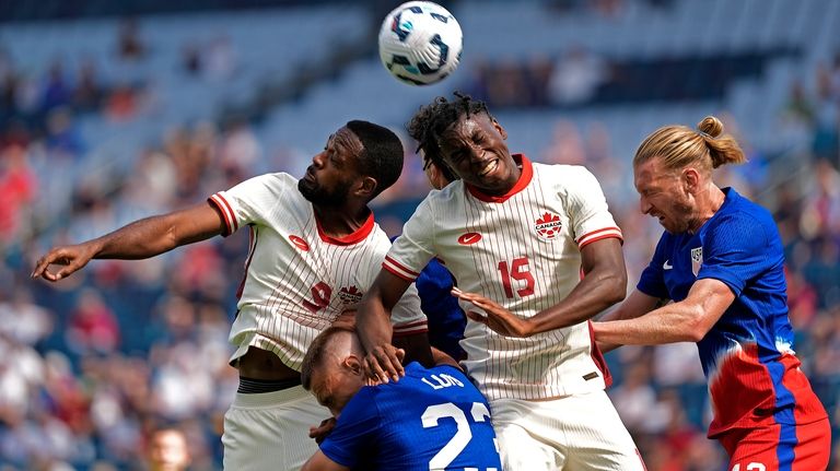 Canada forward Cyle Larin (9) and defender Moïse Bombito (15)...