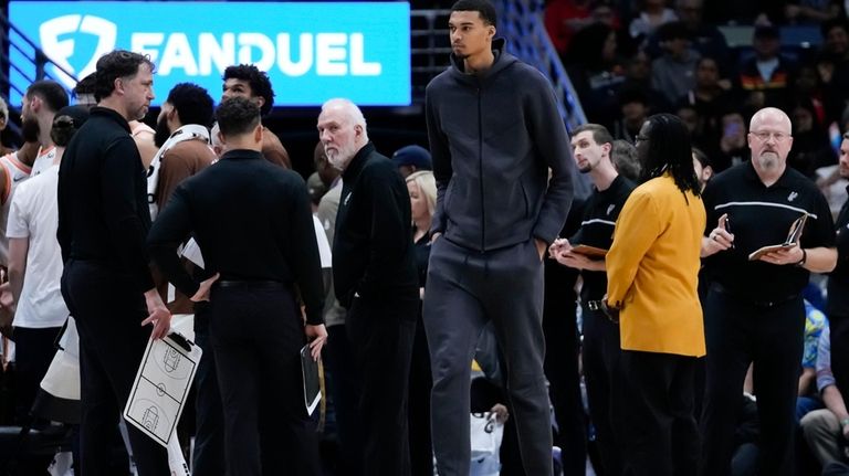 San Antonio Spurs center Victor Wembanyama walks along the bench...