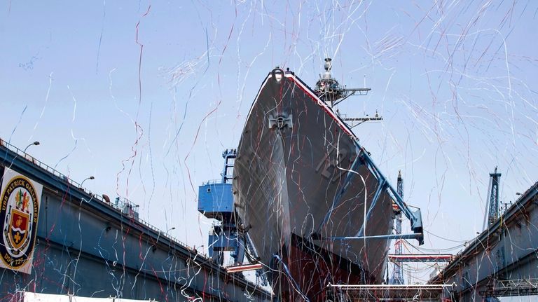 This photo provided by Bath Iron Works shows streamers bursting...