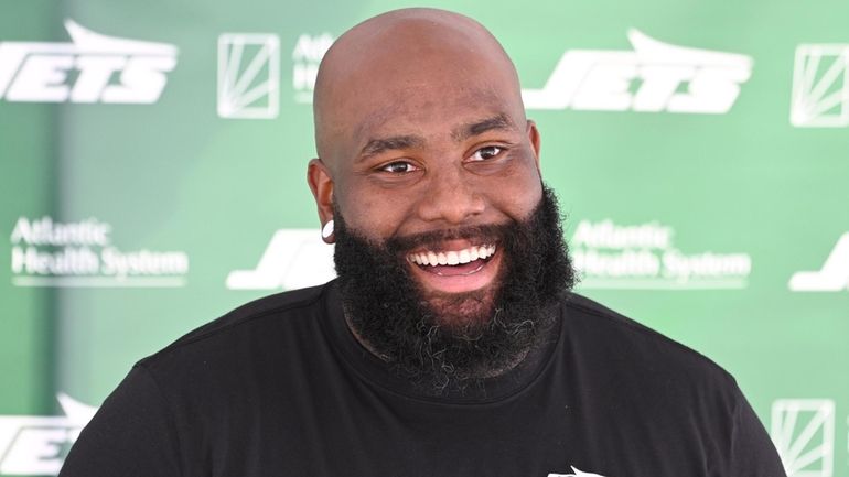 Jets offensive lineman Morgan Moses speaks with the media after practice...