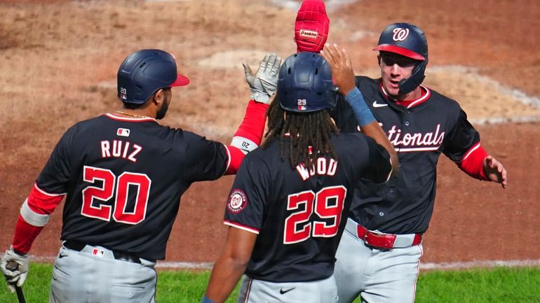 Washington Nationals' Jacob Young, right, celebrates with James Wood (29)...