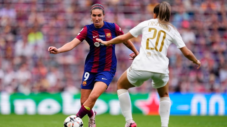 Barcelona's Mariona Caldentey, left, dribbles gthe ball in front of...