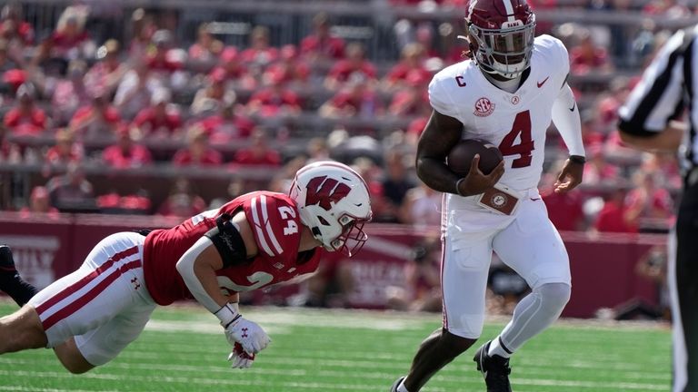 Alabama's Jalen Milroe (4) tries to get past Wisconsin's Hunter...