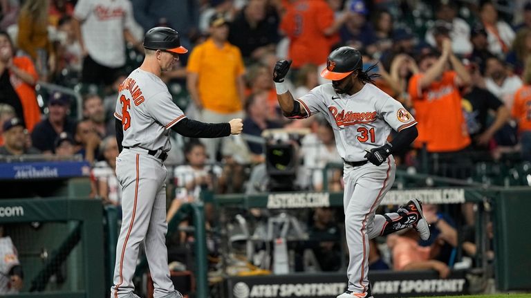 Baltimore Orioles' Cedric Mullins (31) celebrates with third base coach...