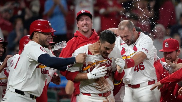 St. Louis Cardinals' Nolan Arenado is congratulated by teammates including...