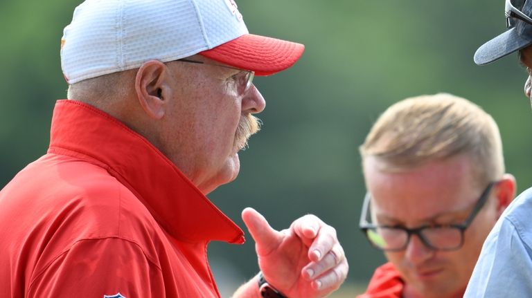 Kansas City Chiefs head coach Andy Reid, left, gives an...