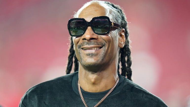 Entertainer Snoop Dogg walks on the field before an NFL...