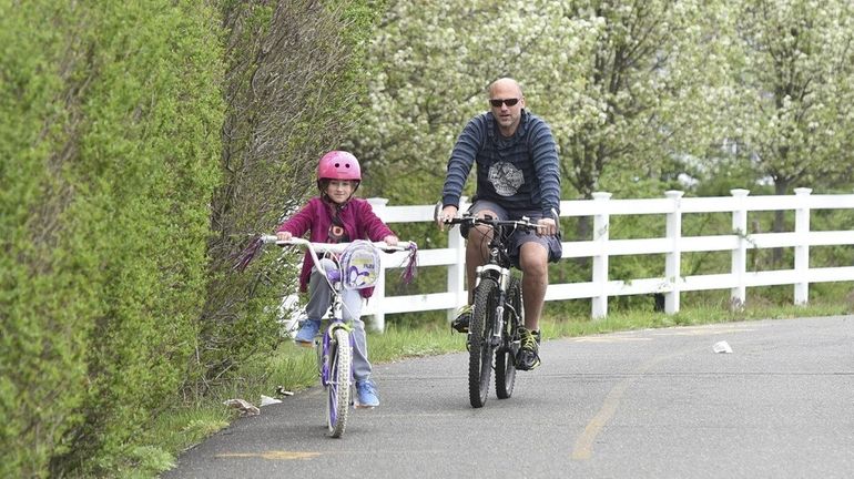 Kevin Graber, of Islip Terrace, rides his bicycle with his...