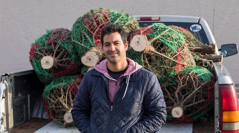 Joseph Venezia loaded his pickup truck for Christmas tree deliveries at...