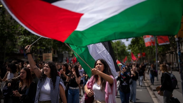 Students wave Palestinian flags as they march to show solidarity...