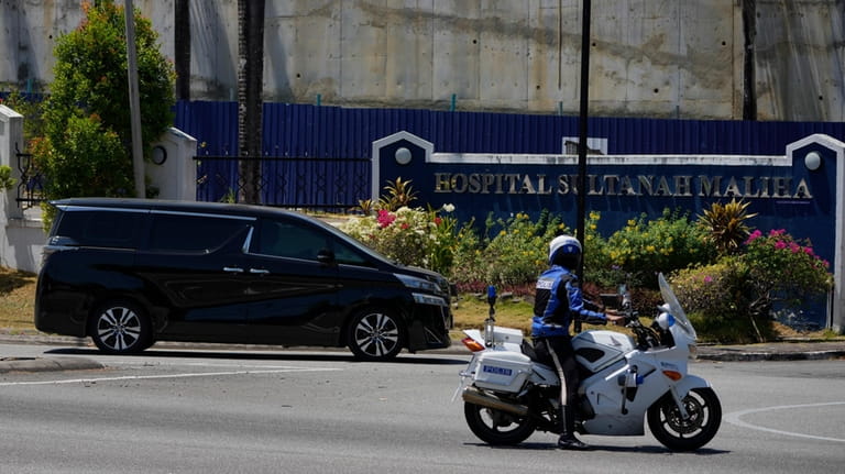 A police outrider escorts a vehicle with a diplomatic license...