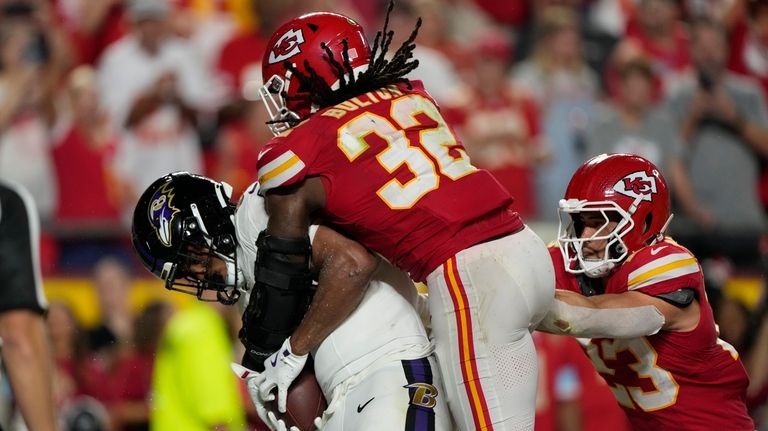 Baltimore Ravens tight end Isaiah Likely, left, catches a pass...