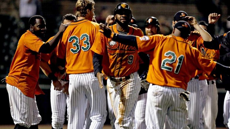 LI Ducks pinch runner P.J. Phillips is surrounded by teammates...