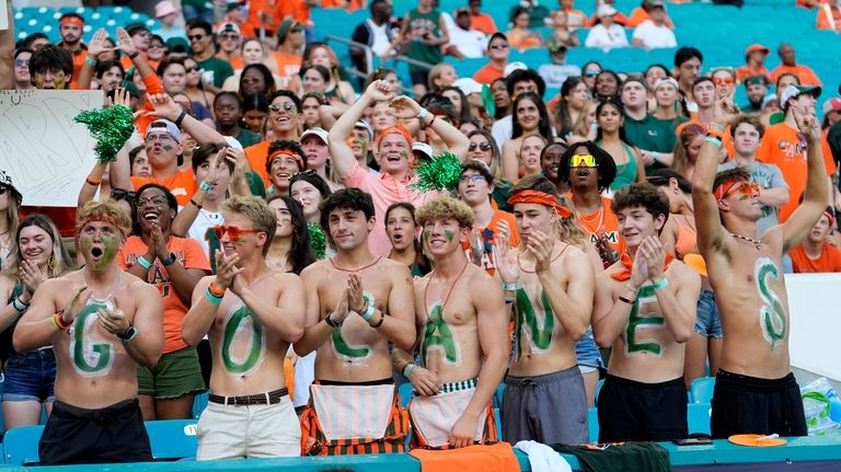 Miami fans cheer before an NCAA football game between Miami...