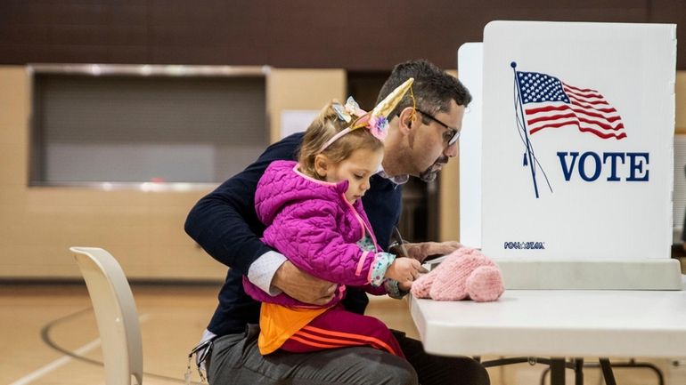 After his daughter Nora, 2, scribbled on his first ballot,...