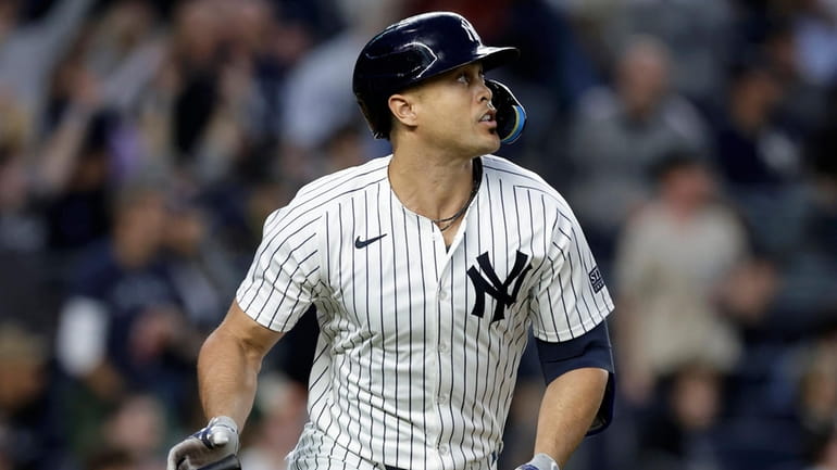 Giancarlo Stanton #27 of the Yankees watches his fourth inning RBI...