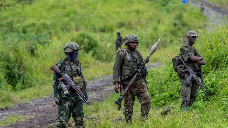 M23 rebels stand with theirs weapons in Kibumba, in the...