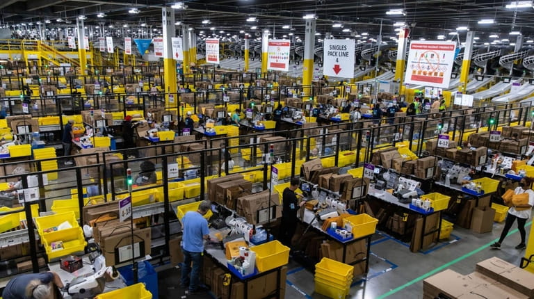 Workers fulfill orders at an Amazon fulfillment center on Prime...