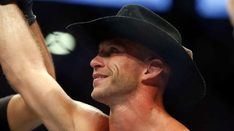 Donald Cerrone raises his hand after defeating Rick Story in...