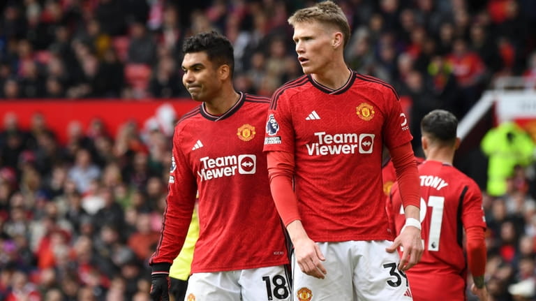 Manchester United's Scott McTominay, right, and Casemiro react as referee...