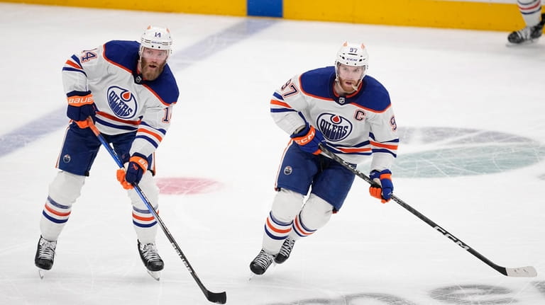 Edmonton Oilers' Mattias Ekholm (14) and Connor McDavid (97) skate...