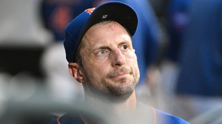 Mets starting pitcher Max Scherzer looks on from the dugout...