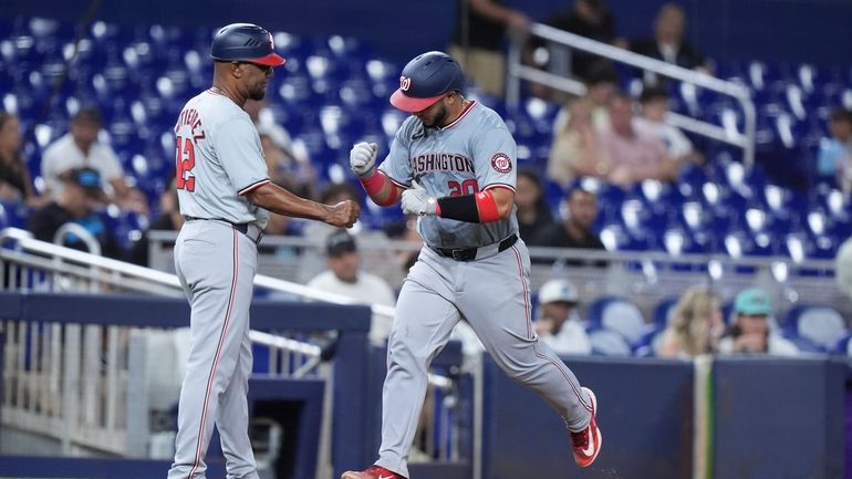 Washington Nationals third base coach Ricky Gutierrez (12) congratulates Keibert...