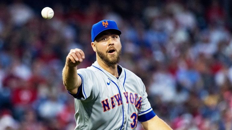 Mets pitcher Tylor Megill (38) throws to first base for...