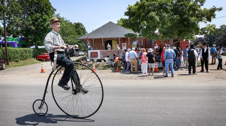 Robert Reichel, of Sayville, rides an old-time high-wheel bike during...