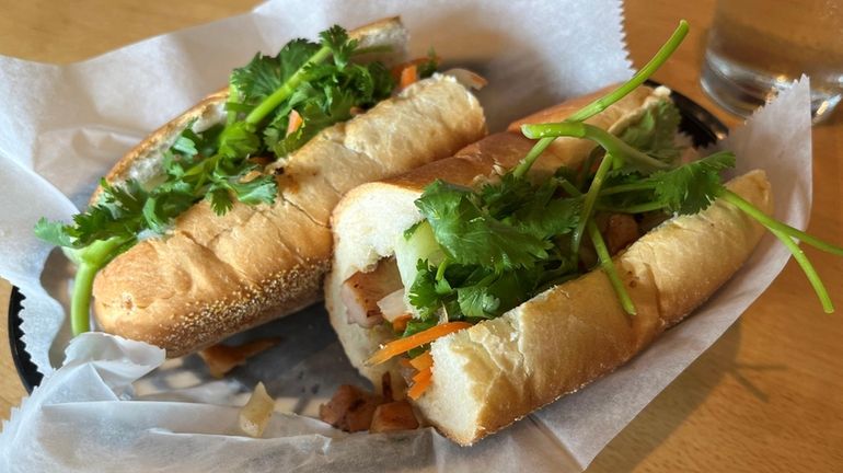 A barbecue chicken bánh mì sandwich with crusty bread at...