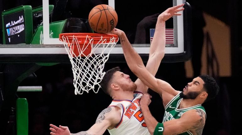 Knicks center Isaiah Hartenstein, left, blocks a shot by Celtics...