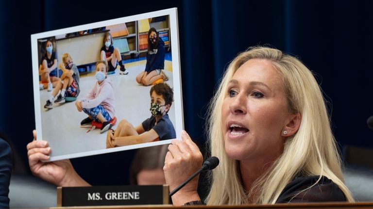 Rep. Marjorie Taylor Greene, R-Ga., holds up a photo as...