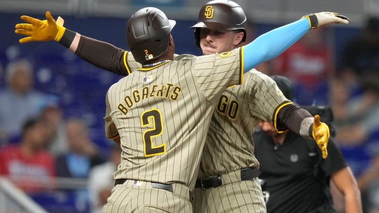 San Diego Padres' Jackson Merrill, right, is met by Xander...