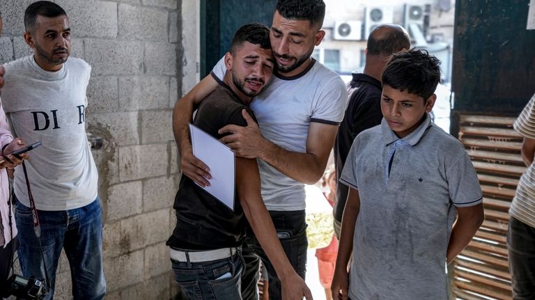 Palestinians mourn their 4-day-old twin relatives, killed in the Israeli...