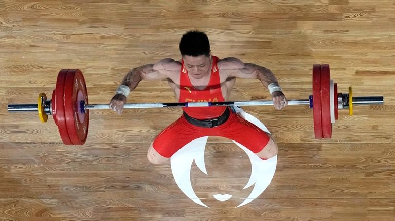 Li Fabin of China competes during the men's 61kg weightlifting...