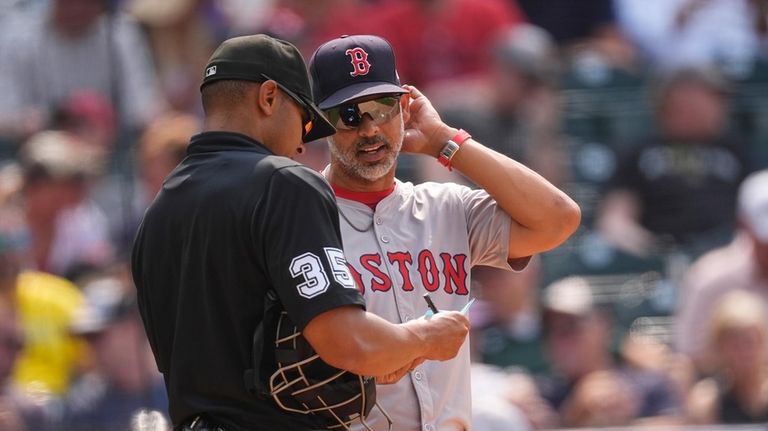 Boston Red Sox manager Alex Cora, right, chekcs in with...