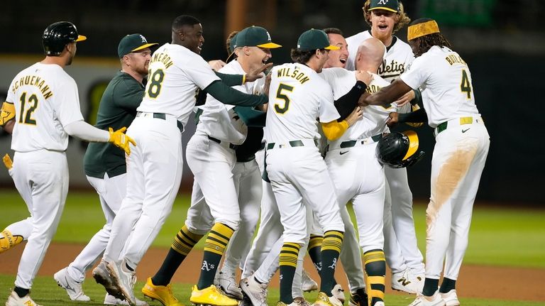 Oakland Athletics players surround Seth Brown as they celebrate his...