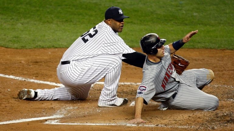 Joe Mauer of the Minnesota Twins slides into home safely...