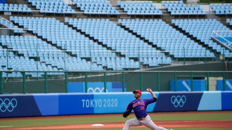 Backdropped by empty seats, Dominican Republic starting pitcher Cristopher Mercedes...