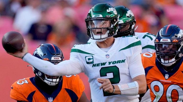 Jets quarterback Zach Wilson throws under pressure against the Broncos during...