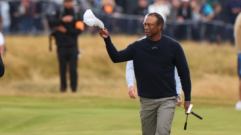 Tiger Woods of the United States waves as he walks...